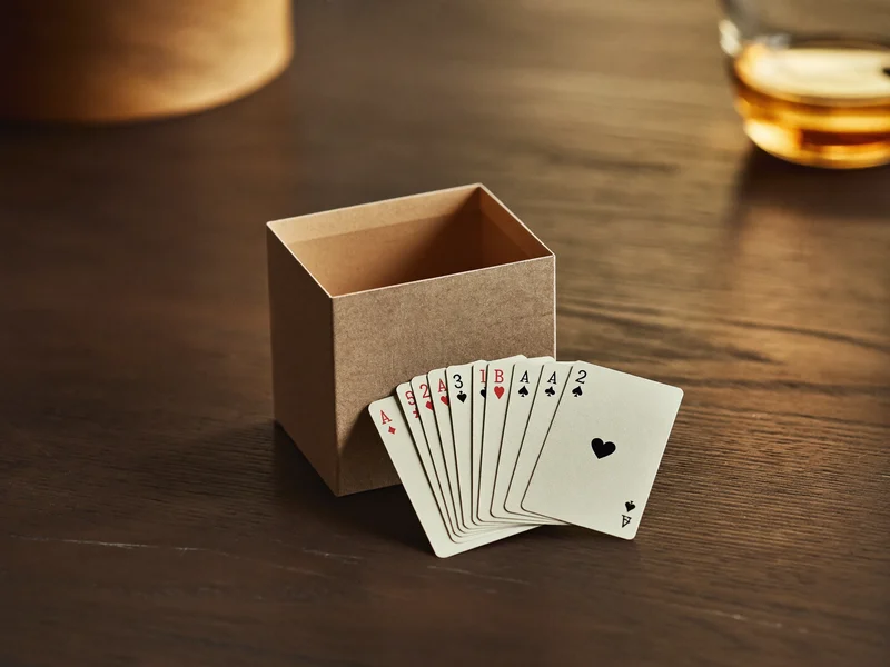 Illustration eines Kartenspiel-Sets mit unbedruckten Karten neben geöffneter Pappschachtel