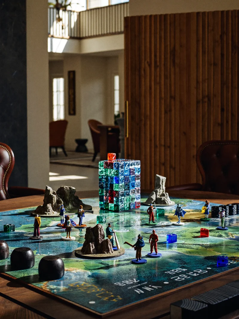 Illustration eines kooperativen Abenteuerspiels mit Miniaturfiguren, Geländebausteinen und Würfelturm